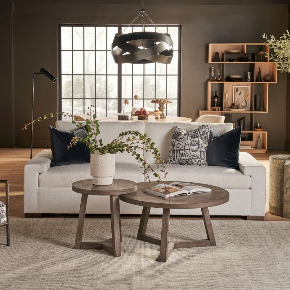 Modern white upholstered apartment sofa with low-profile arms, boxy cushions, and dark wood feet.