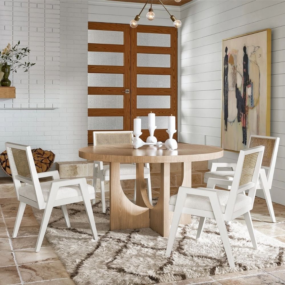 Sonora Arm Chair featuring a white wood frame, woven rattan backrest, and soft upholstered seat in neutral fabric.
