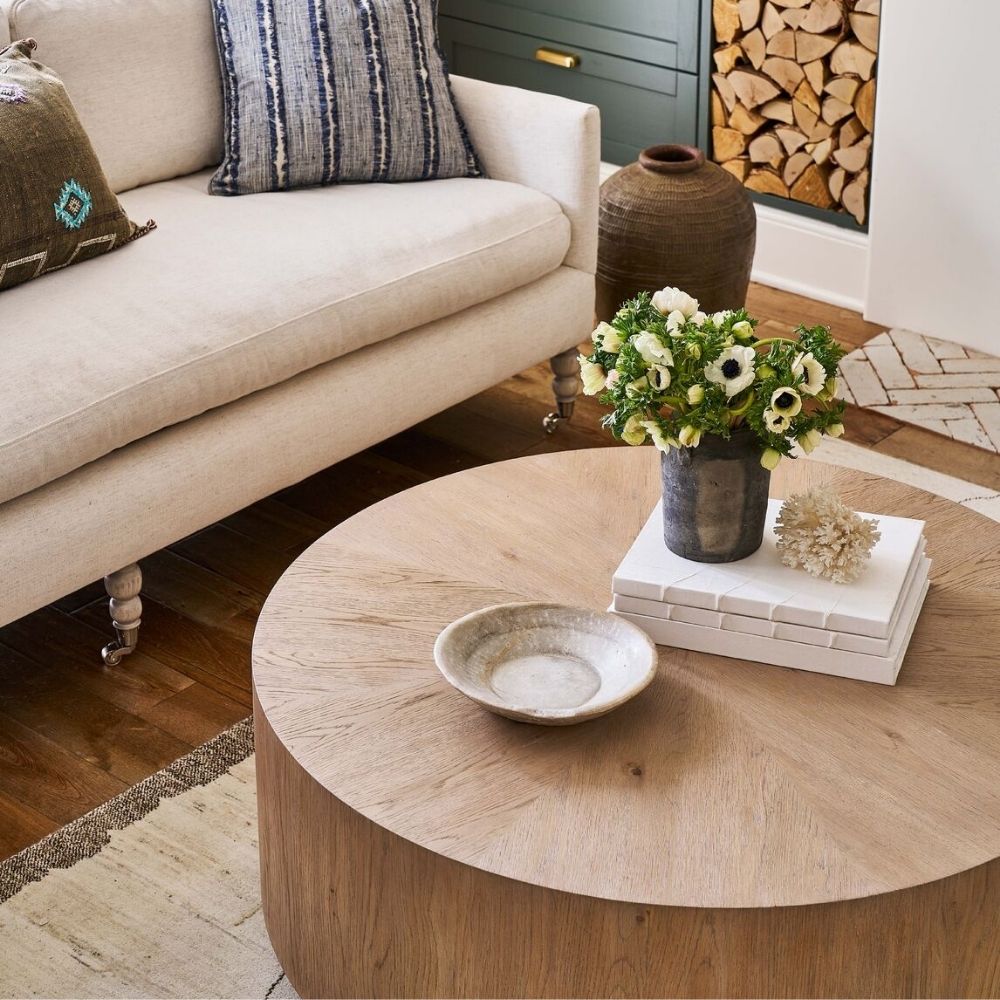 Round solid wood cocktail table with a drum silhouette and sunburst wood grain top pattern.