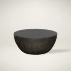 Round black coffee table with a smooth, matte finish and softly curved base in a minimalist drum silhouette