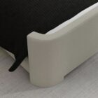 The Tilburg Bed featuring a high, fully upholstered headboard and footboard in a soft neutral fabric with a clean, curved silhouette.The Tilburg Bed featuring a high, fully upholstered headboard and footboard in a soft neutral fabric with a clean, curved silhouette.