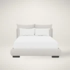 Upholstered Bed with Double-Cushion Headboard and Rounded Base, Dressed in Neutral Bedding.