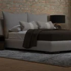 Upholstered Bed with Double-Cushion Headboard and Rounded Base, Dressed in Neutral Bedding.