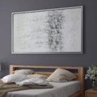 Abstract wall art featuring a softly blended palette of whites, greys, and subtle metallics, framed in a slim black frame.