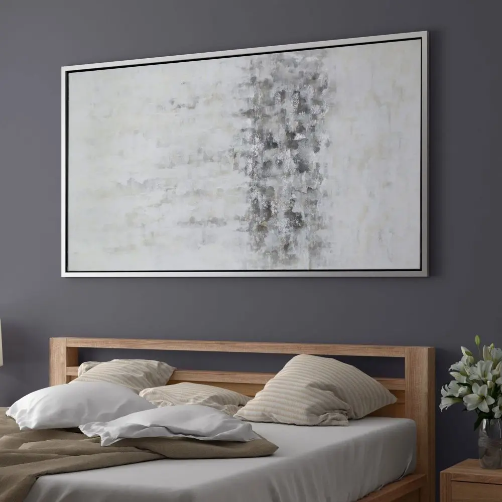Abstract wall art featuring a softly blended palette of whites, greys, and subtle metallics, framed in a slim black frame.