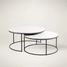 Set of two round nesting coffee tables with white marble tops and thin black metal bases, shown partially stacked.