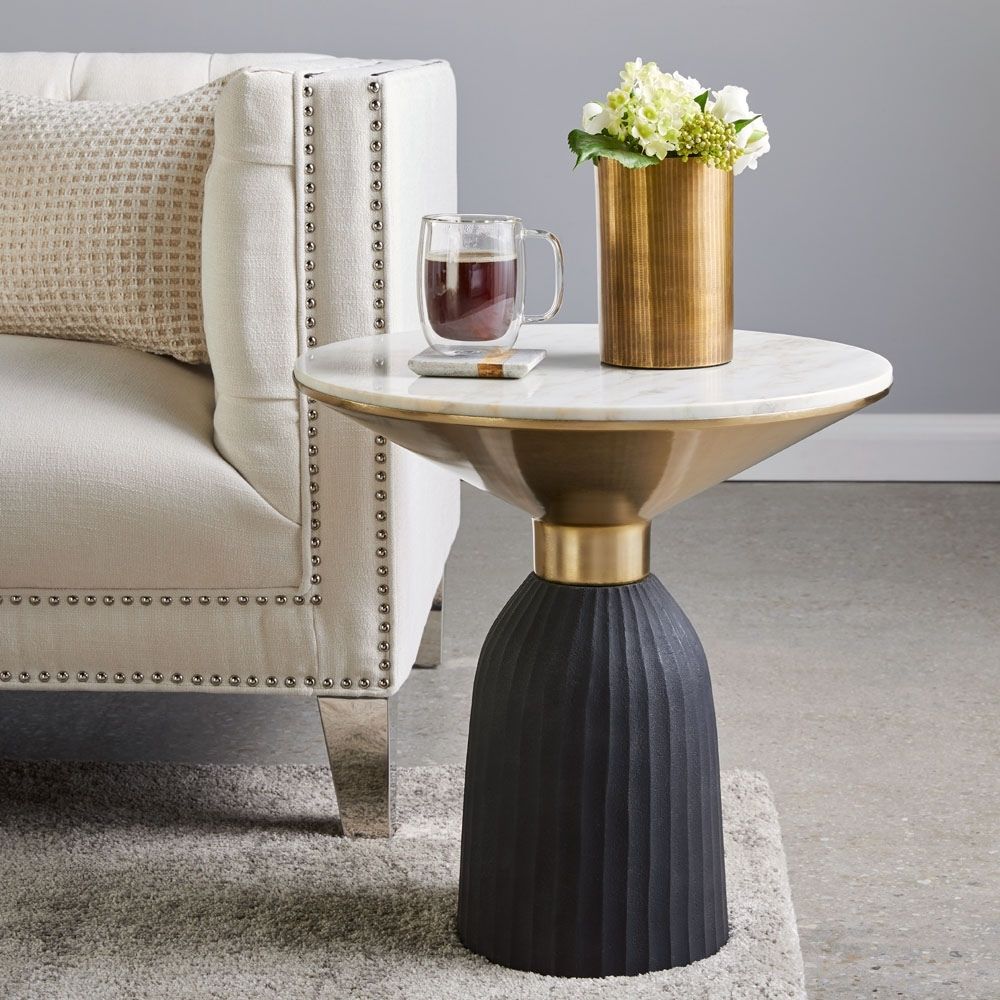 Sculptural end table featuring a white round marble top, flared gold accent, and fluted black wood base.