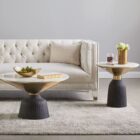 Sculptural end table featuring a white round marble top, flared gold accent, and fluted black wood base.