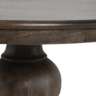 60-inch round pedestal dining table in dark-stained solid wood with a sculptural, turned base and smooth beveled edge.