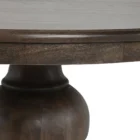 60-inch round pedestal dining table in dark-stained solid wood with a sculptural, turned base and smooth beveled edge.