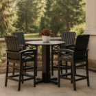 Outdoor round bistro table with four matching high-back chairs in black wood finish, styled with a white planter and red foliage, set on a stone patio overlooking lush greenery. beaver springs furniture