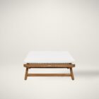 Outdoor teak stool with white cushion and slatted wood frame.