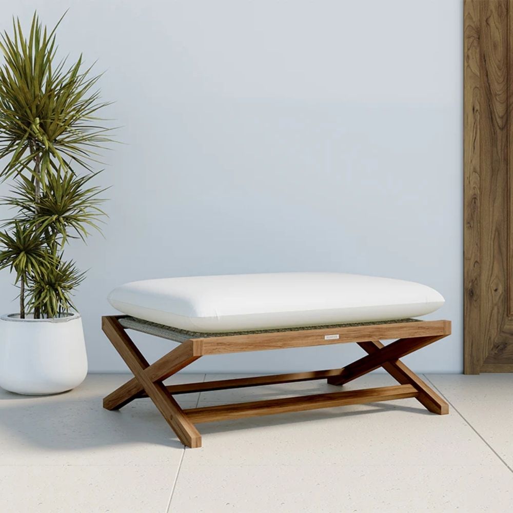 Outdoor teak stool with white cushion and slatted wood frame.