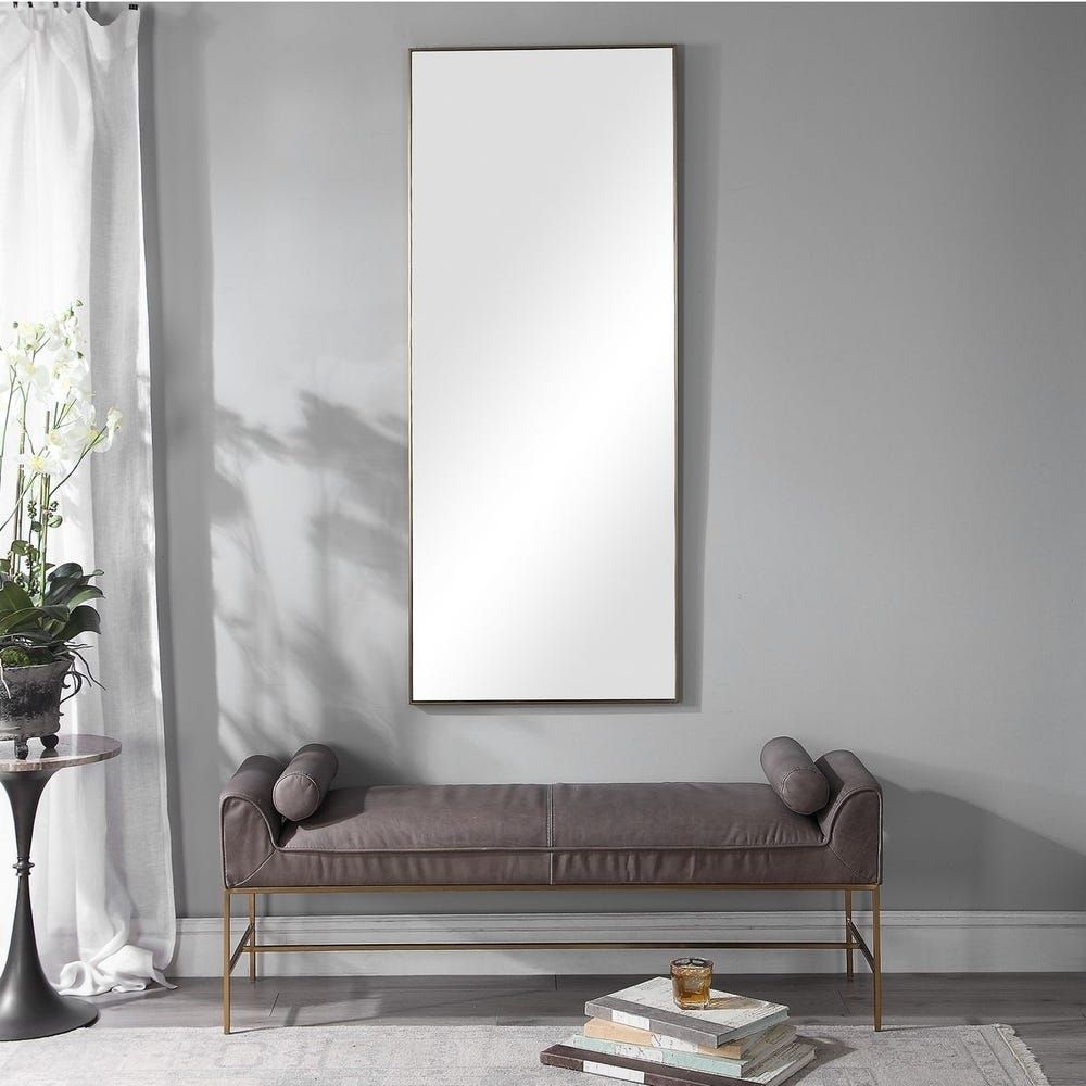 A modern full-length rectangular mirror with a slim metallic frame and a minimalist design.