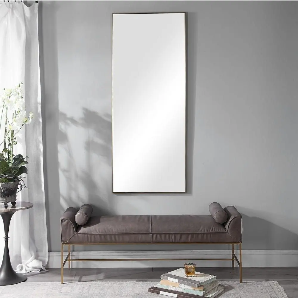 A modern full-length rectangular mirror with a slim metallic frame and a minimalist design.