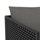 Modern outdoor dining chair with charcoal cushions, black woven frame, and sleek stainless steel base.