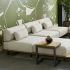 Contemporary outdoor armless lounge chair with white cushions, natural wood base, and black metal legs.