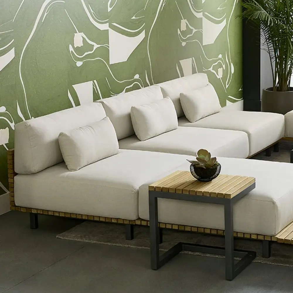 Contemporary outdoor armless lounge chair with white cushions, natural wood base, and black metal legs.