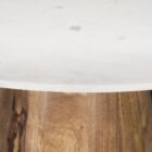 Round white marble dining table with a solid wood tapered cone-shaped base in a natural finish.