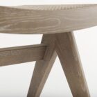 Low wood accent stool with woven cane seat and sculpted legs in a weathered oak finish.