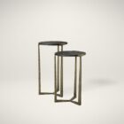 Pair of round nesting accent tables with charcoal wood tops and antique brass metal frames.