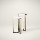 Set of two round white marble nesting tables with antique brass metal bases.