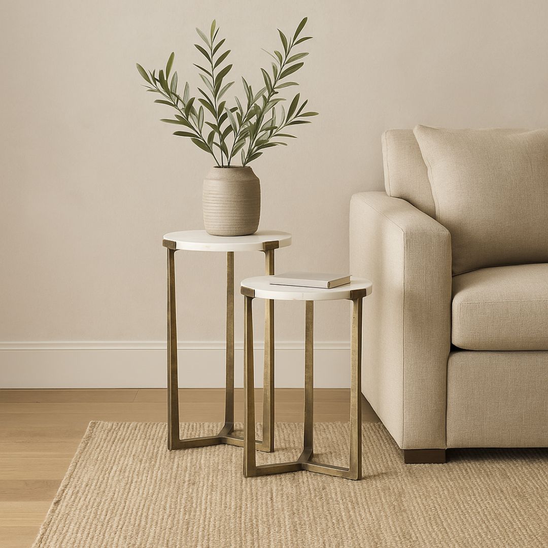 Set of two round white marble nesting tables with antique brass metal bases.