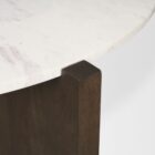 Round marble-top coffee table with cross-shaped dark wood base.