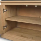 Tall bookcase with brass-toned metal frame, natural wood shelves, and a closed wood cabinet at the base.
