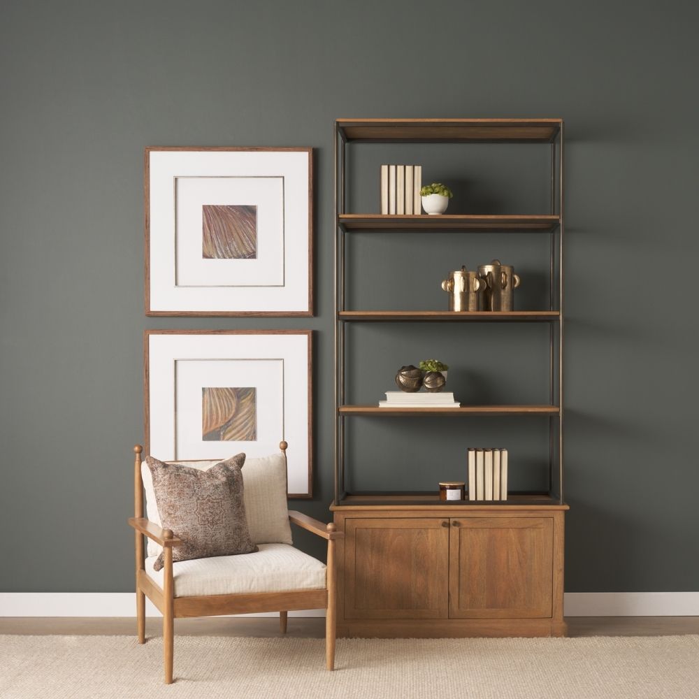 Tall bookcase with brass-toned metal frame, natural wood shelves, and a closed wood cabinet at the base.