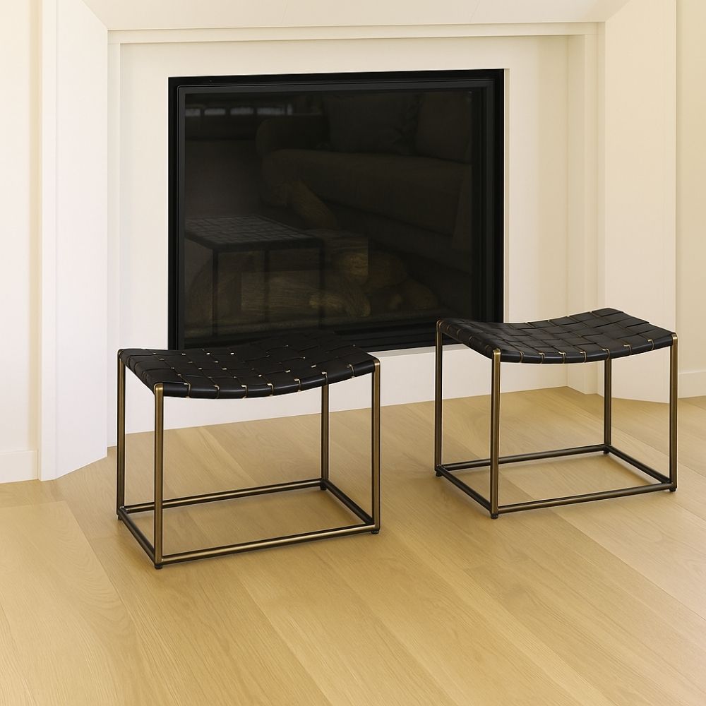 Modern ottoman with black woven leather seat and brass-finished metal frame.