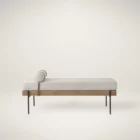 Mercana Colburne bench with beige cushion, natural wood base, and black metal legs, featuring a strapped bolster pillow.