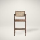 Mid-century style wooden bar stool with cane backrest, beige fabric seat, and angled frame.