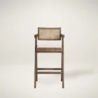 Mid-century style wooden bar stool with cane backrest, beige fabric seat, and angled frame.