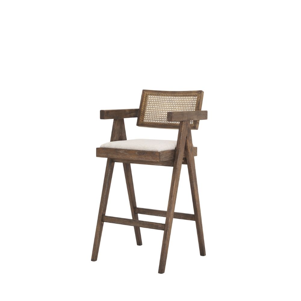Mid-century style wooden bar stool with cane backrest, beige fabric seat, and angled frame.