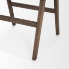 Mid-century style wooden bar stool with cane backrest, beige fabric seat, and angled frame.