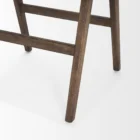 Mid-century style wooden bar stool with cane backrest, beige fabric seat, and angled frame.
