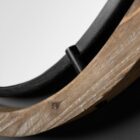 Round wall mirror with mixed wood and metal frame in industrial black and natural finish.