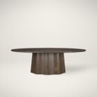 Dark wood oval dining table with sculpted fluted pedestal base.