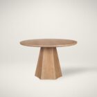 Round natural wood dining table with sculptural pedestal base.