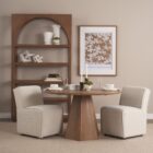 Round natural wood dining table with sculptural pedestal base.