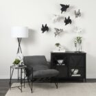 Black metal accent cabinet with glass double doors featuring crisscross design and interior shelving.