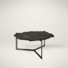 Irregular black stone coffee table with a jagged, organic edge and industrial hammered metal base.