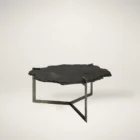 Irregular black stone coffee table with a jagged, organic edge and industrial hammered metal base.