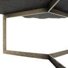 Irregular black stone coffee table with a jagged, organic edge and industrial hammered metal base.