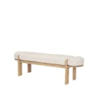 Light oak bench with rounded upholstered cushion in soft neutral fabric.