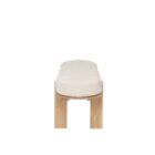 Light oak bench with rounded upholstered cushion in soft neutral fabric.