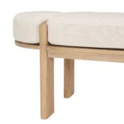 Light oak bench with rounded upholstered cushion in soft neutral fabric.