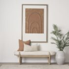 Light oak bench with rounded upholstered cushion in soft neutral fabric.