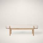Light oak bench with rounded upholstered cushion in soft neutral fabric.